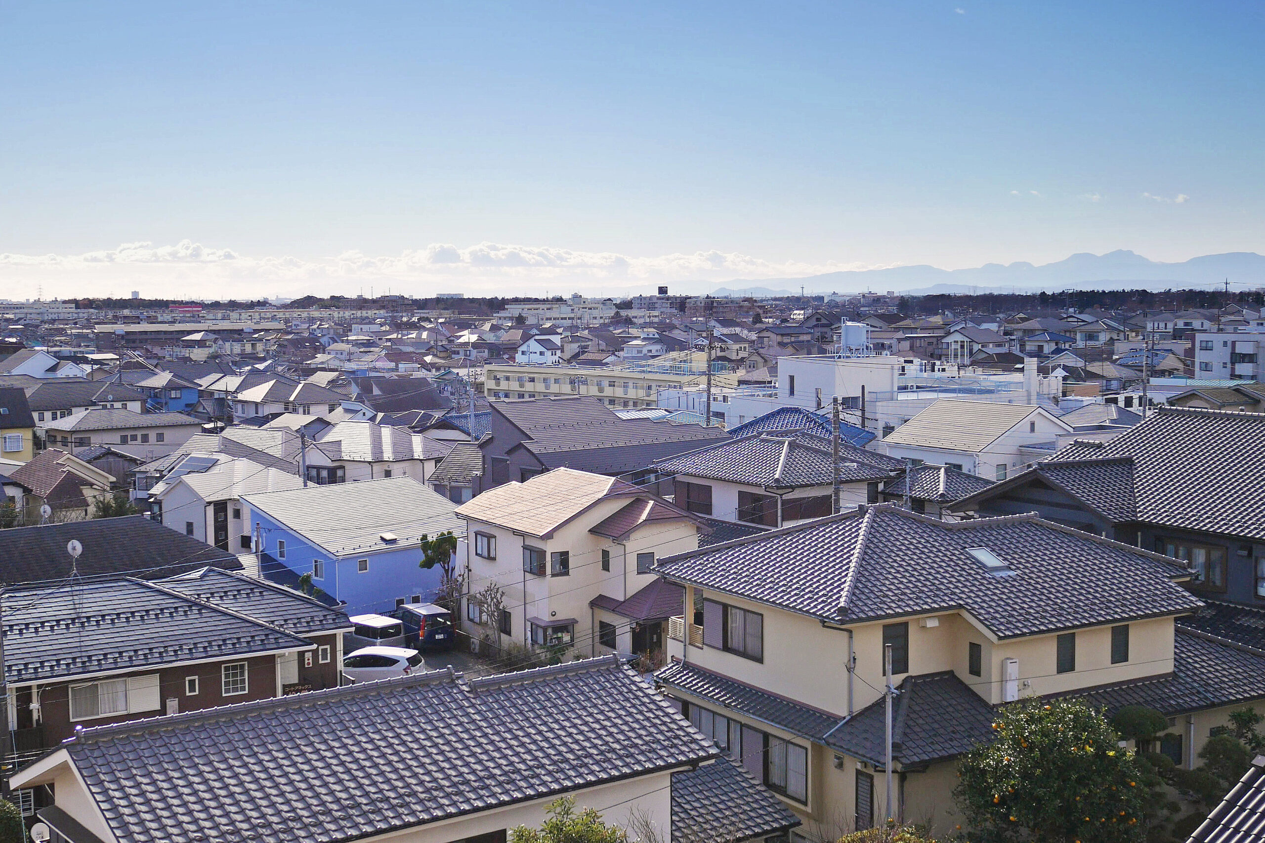 冬の金沢市内、雪が積もった戸建て住宅の屋根